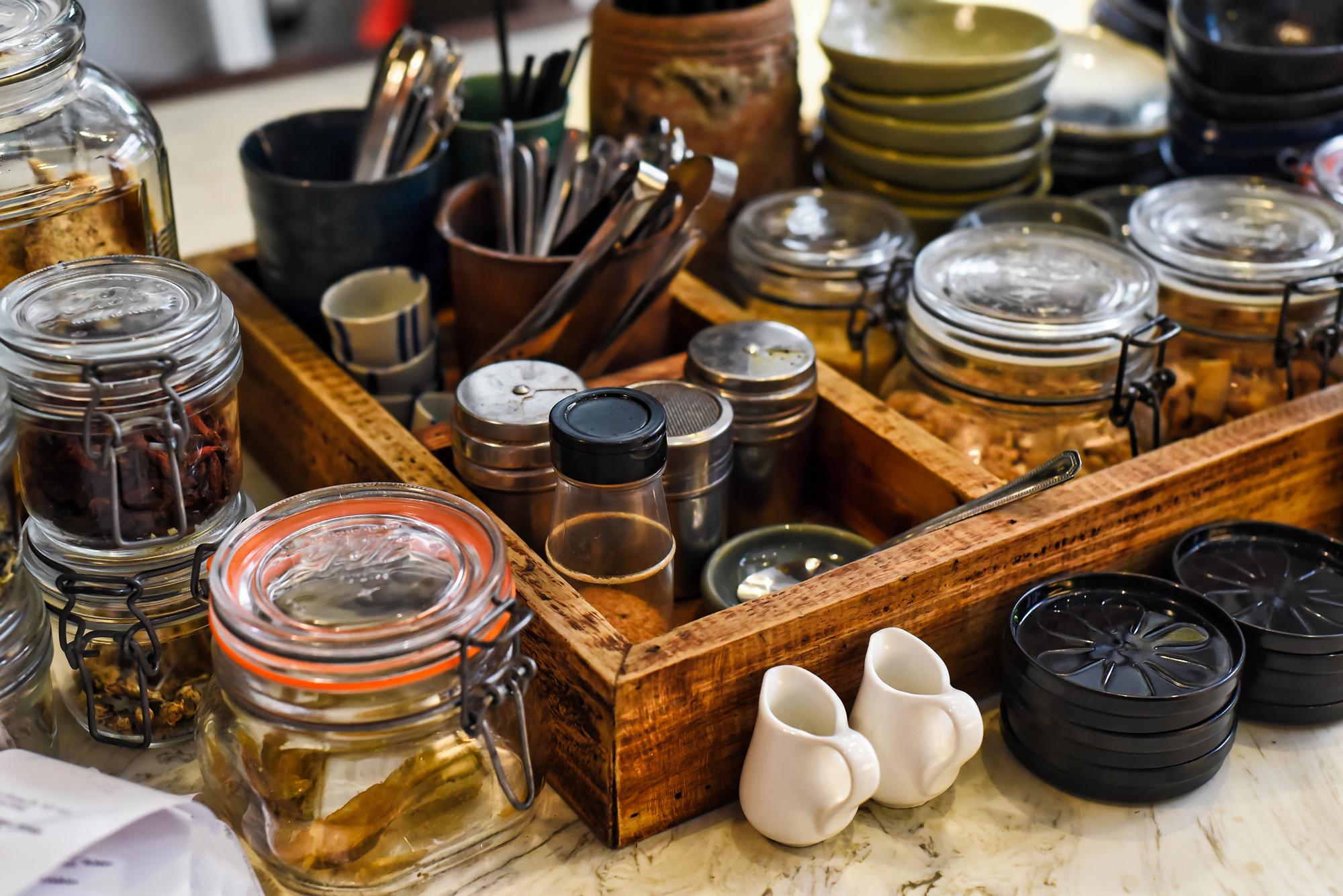 Workshop counter with jars of spices and tasting spoons